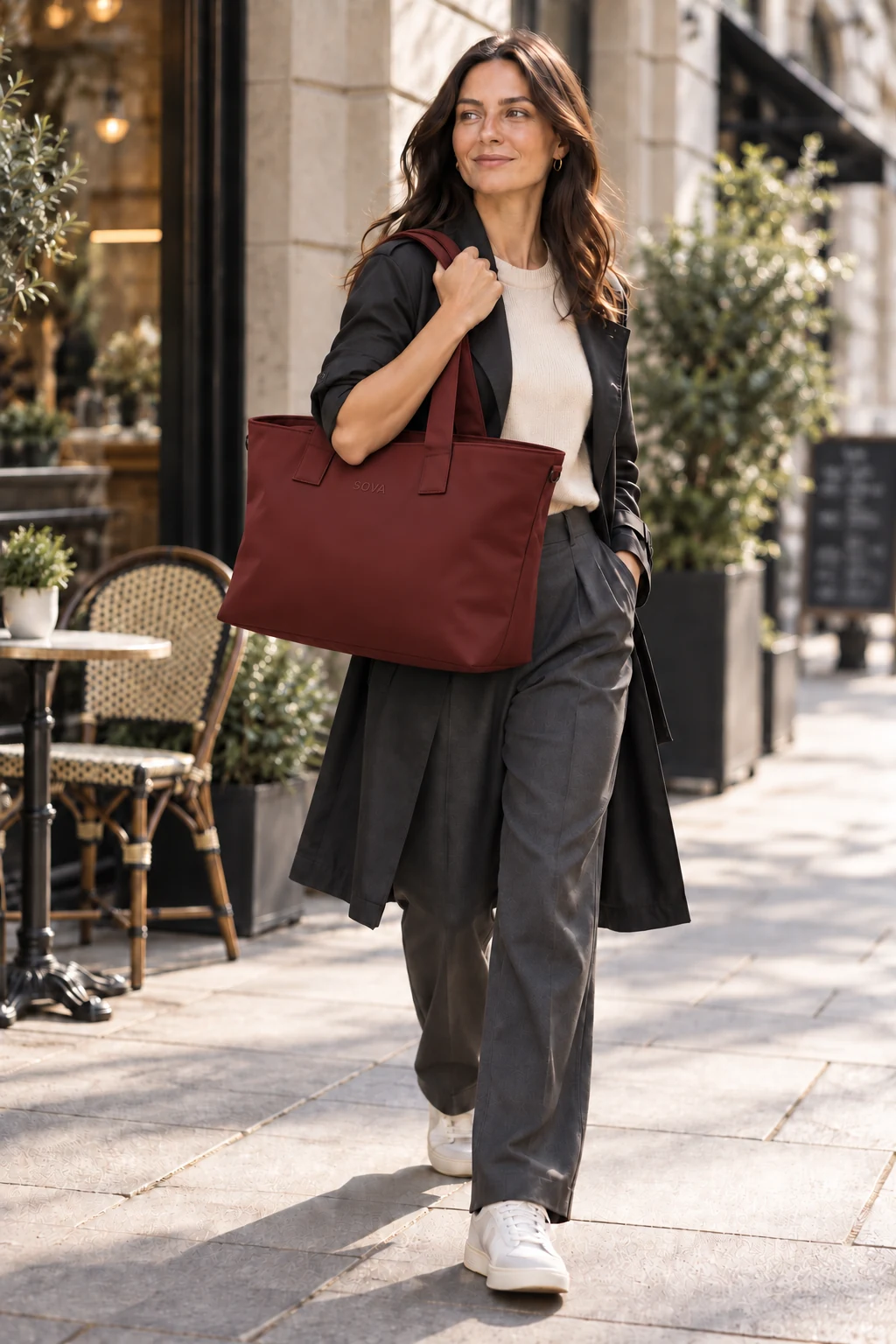 Woman carrying the Burnt Cherry SOVA tote on a city street